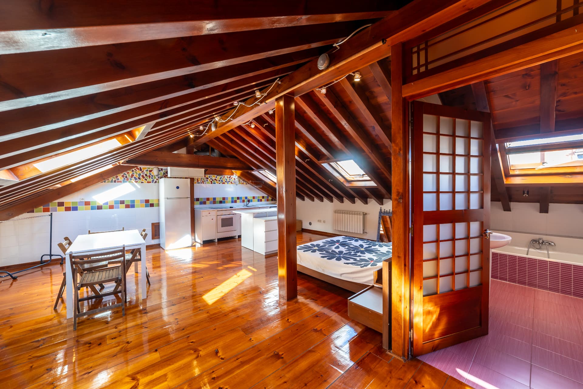 Buhardilla de madera con celosías japonesas y espacio para cocina